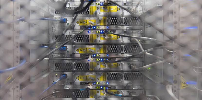 Close-up van een serverkast met netwerkbekabeling en indicatorlampjes in een datacenteromgeving